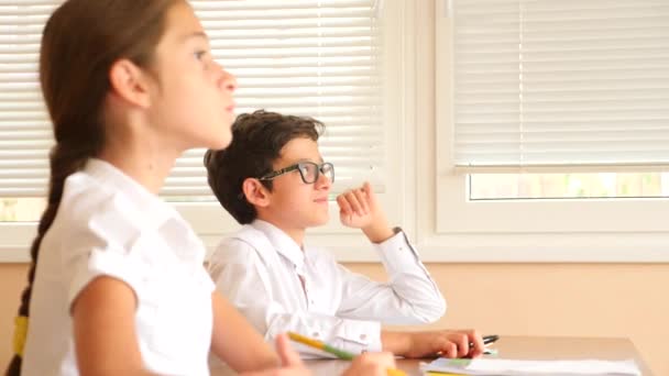 Educación, personas y concepto de aprendizaje - grupo de estudiantes con cuadernos prueba de escritura en la escuela. 4k. Movimiento lento — Vídeos de Stock