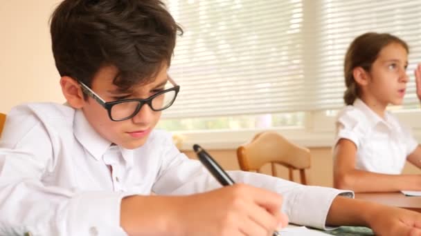 Oktatás, az emberek és a tanulás fogalma - csoportja a hallgatók az írás notebook teszt az iskolában. 4 k. lassú mozgás — Stock videók