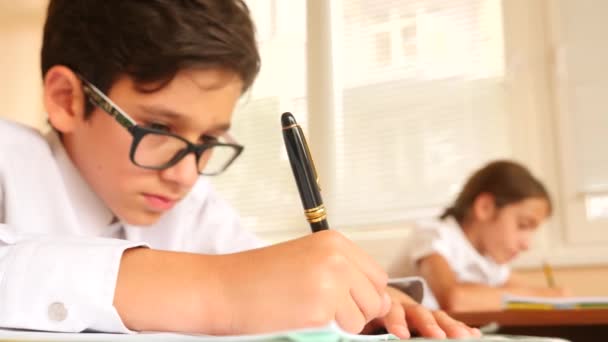 Educación, personas y concepto de aprendizaje - grupo de estudiantes con cuadernos prueba de escritura en la escuela. 4k. Movimiento lento — Vídeos de Stock