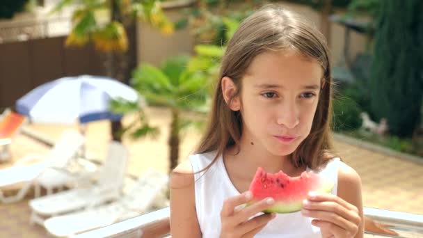 Mooie brunette meisje met lang haar die een watermeloen buiten eten. 4 k. Slowmotion. — Stockvideo