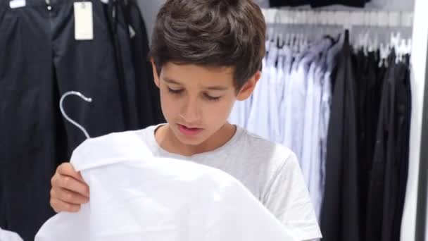 Adolescent regardant les vêtements dans la boutique à la mode. 4k au ralenti — Video