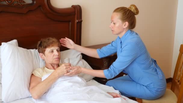 Eine Krankenschwester hilft einem Patienten in seinem Schlafzimmer. 4k, Zeitlupe — Stockvideo