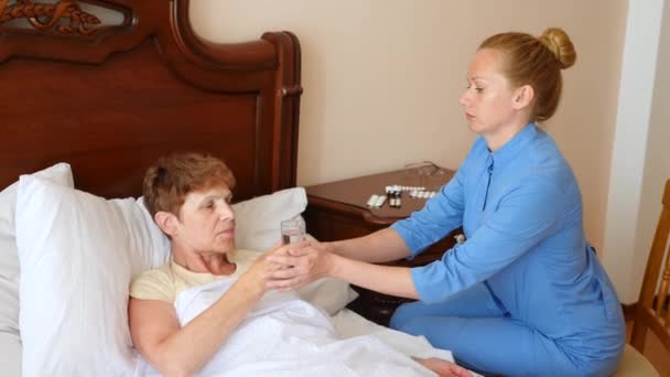 A nurse helps a patient in his bedroom. 4k, slow motion — Stock Video