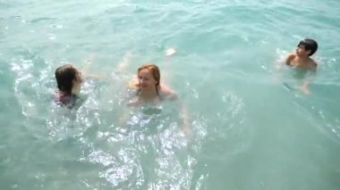 Aile, iki çocuk, bir kardeşi ve kız sahilde okyanus dalgaları sıçramasına ile. Onlar dalga yakalamak ve mutluyuz. 4 k. ağır çekim