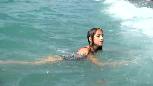 Dospívající dívka se sype do vlny oceánu na pláži. Úlovky na vlně a je šťastný. 4 k. Zpomalený pohyb — Stock video