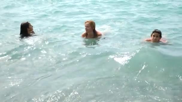 Rodina se dvěma dětmi, bratra a sestry, omývané vlnami oceánu na pobřeží. Chytit vlnu a jsou šťastní. 4 k. Zpomalený pohyb — Stock video