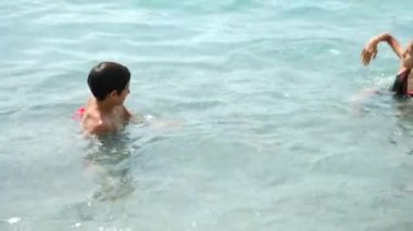 Aile, iki çocuk, bir kardeşi ve kız sahilde okyanus dalgaları sıçramasına ile. Onlar dalga yakalamak ve mutluyuz. 4 k. ağır çekim