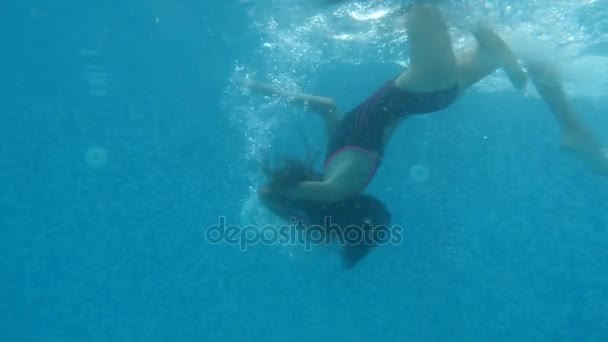 Esmer, genç kız su altında yüzüyor. Sualtı çekim. 4 k. ağır çekim. — Stok video