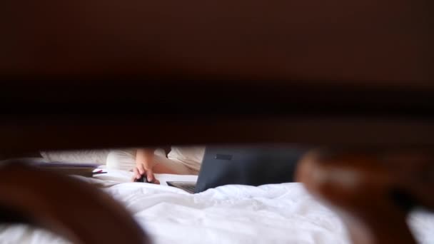 Life style frilansar. Kvinnan arbetar bakom en laptop på sin säng hemma. 4k, Slowmotion — Stockvideo