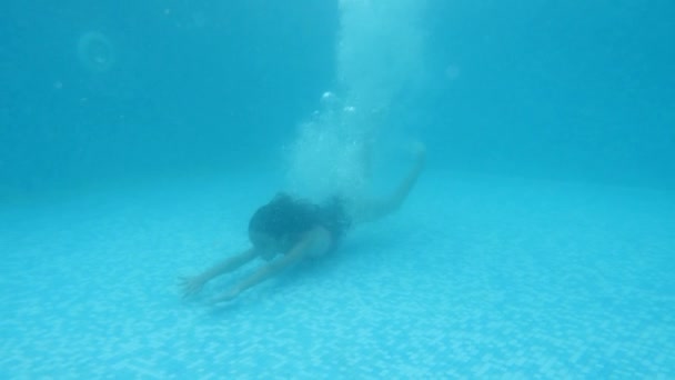 布鲁内特，十几岁的女孩在水下游泳。水下拍摄。4 k.慢动作. — 图库视频影像