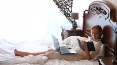 Yaşam tarzı freelancing. Kadın evde yatağında bir dizüstü bilgisayar çalışıyor. 4k, ağır çekim