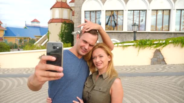 Mutlu çift bir selfie bir şehirde güneşli bir günde sokak fotoğrafçılığı turist. 4k, ağır çekim. — Stok video