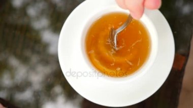 Biri şeker limon ile kupa yeşil çay ile hareket ediyor. 4k, ağır çekim.