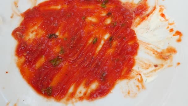 Пустые грязные тарелки с остатками кетчупа. Мужские руки рисуют сердце на останках кетчупа. 4k, slow-motion, крупным планом — стоковое видео