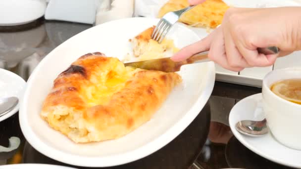 Gruzínské chačapury megruli se sýrem. Někdo bere kousek chačapury z talíře. Zpomalený pohyb. 4k — Stock video