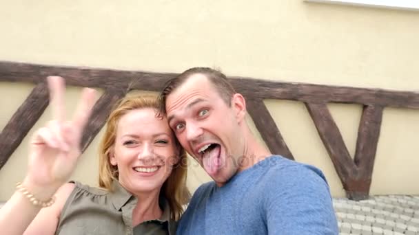 Lyckliga paret turister fotografera en selfie i en stadsgata i en solig dag. 4k, Slowmotion. — Stockvideo