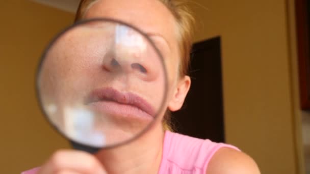 La femme sans maquillage avec une loupe à la main. 4k, au ralenti — Video