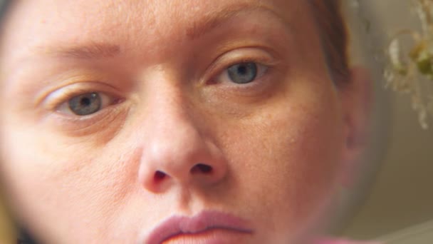 De vrouw zonder make-up met een vergrootglas in een hand. 4k, slow-motion — Stockvideo