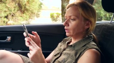 Bir kadın sürücüsünün yanında araba sürüş ve telefonda konuşuyor. 4k, ağır çekim