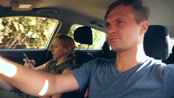 Жінка їде в машині поруч з водієм і розмовляє по телефону. 4k, повільний рух — стокове відео