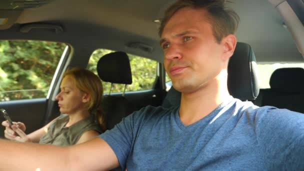 En kvinna är körning i bilen bredvid föraren och pratar i telefon. 4k, slow motion — Stockvideo