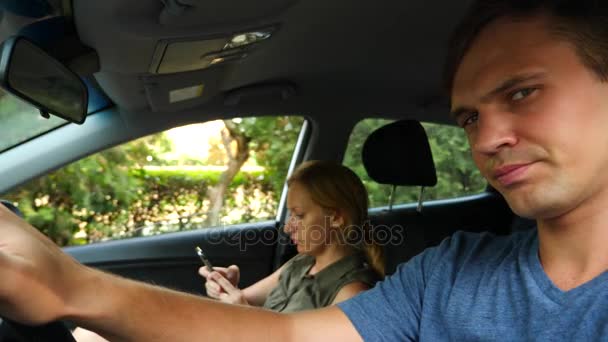 Женщина едет в машине рядом с водителем и разговаривает по телефону. 4k, slow-motion — стоковое видео
