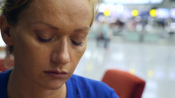 Жінка використовує смартфон в аеропорту, що чекає. Очікування польоту в аеропорту. 4k, повільний рух — стокове відео