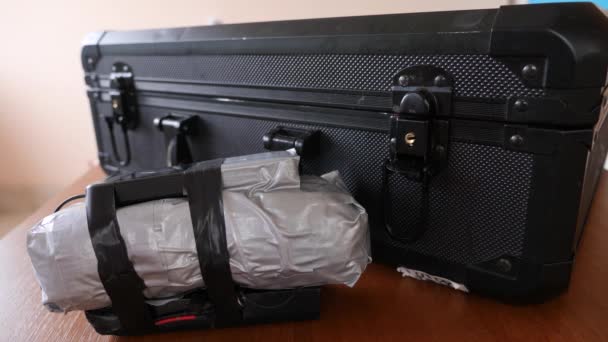 Un hombre pone un artefacto explosivo casero en su maleta. Preparación del acto terrorista. 4k. Movimiento lento — Vídeos de Stock