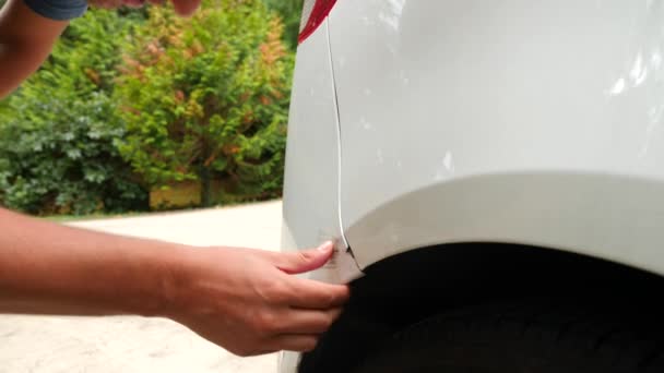 Regardant un véhicule endommagé. l'homme inspecte les dommages à la voiture après un accident. 4k, au ralenti — Video