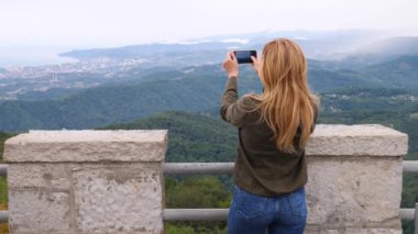 Yavaş çekimde bir selfie alarak dağın tepesine genç kadın. Genç uzun yürüyüşe çıkan kimse kadın alarak dağın zirvesine dağlardan telefonunuza bir görünümünü fotoğraflar. 4k