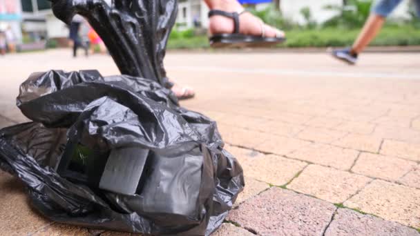 Un artefacto explosivo casero en una bolsa negra, en la calle. Preparación de un acto terrorista. 4k. Movimiento lento — Vídeo de stock