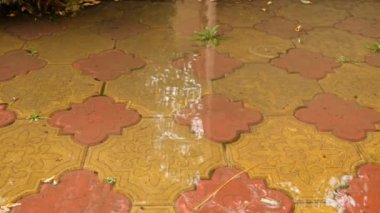 Çıplak ayak splash su birikintileri üzerinden kırmızı döşeme havuza alınmış bir yağmur fırtınası sırasında hareket yavaşladı. 4k