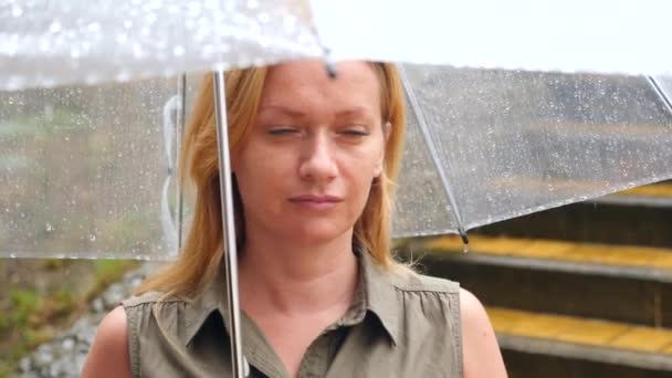 Una mujer está de pie bajo un paraguas. Lluvia torrencial de verano. 4k, cámara lenta — Vídeo de stock