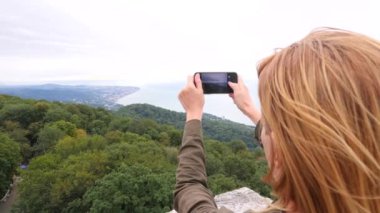 Yavaş çekimde bir selfie alarak dağın tepesine genç kadın. Genç uzun yürüyüşe çıkan kimse kadın alarak dağın zirvesine dağlardan telefonunuza bir görünümünü fotoğraflar. 4k