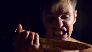 Deli bir adam, sürükleyici bir bıçak, acımasız bir manyak elleri kan içinde. 4k, ağır çekim