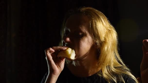 Une jeune femme boulimique a une crise de faim nocturne. Elle mange des saucisses avec des petits pains et de la mayonnaise avec gourmandise. 4k, au ralenti — Video