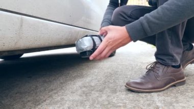 Bir erkek bir ev yapımı patlayıcı arabanın altına koyar. Terör eylemi hazırlanması. 4 k. ağır çekim