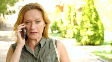 Sarışın konuşuyor küfür ve bağırarak, yaz, şehirde telefonla kamera hareket kızgındır. 4 k. ağır çekim