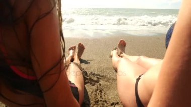 Anne ve kızı ve oturma Yalı, onlar bacaklar su sıçrama, slowmotion. Dalga bacaklar kapsar. 4k