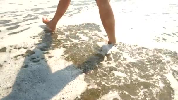 Slow Motion z bliska: Młoda kobieta z długimi nogami, chodzenie na plażę i rozpylanie wody morskiej do aparatu. 4k — Wideo stockowe