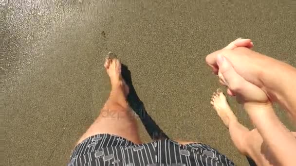 Para spacer wzdłuż plaży. Zbliżenie stóp i fale. Zwolnionym tempie. 4k — Wideo stockowe