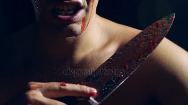 Deli bir adam, sürükleyici bir bıçak, acımasız bir manyak elleri kan içinde. 4k, ağır çekim