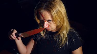 Deli bir kadın, sürükleyici bir bıçak, acımasız bir manyak elleri kan içinde. 4k, ağır çekim