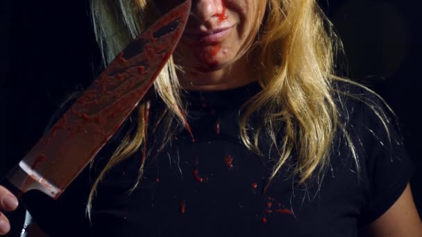 Een gekke vrouw, een aangrijpende mes, bedekt met bloed, de handen van een meedogenloze maniak. 4k, slow-motion — Stockvideo
