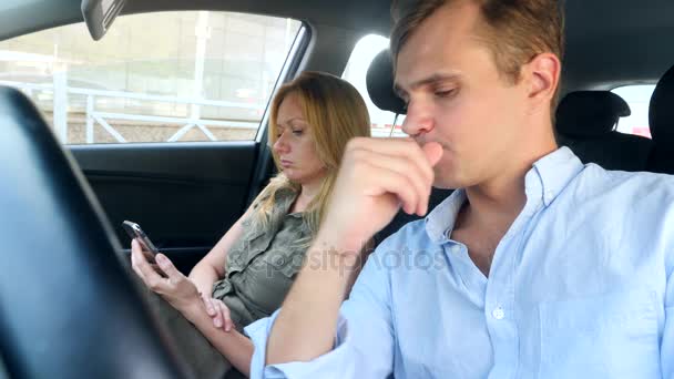 Man driver solicits flicka av en passagerare, som ser till en smartphone. 4k, slow motion — Stockvideo