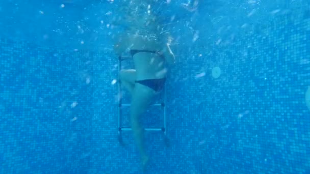 Женщина выходит из бассейна, стреляя под водой. 4k, slow motion — стоковое видео