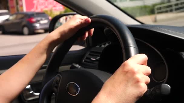 Крупным планом руки на руле автомобиля. Солнце светит. 4k, slow motion — стоковое видео