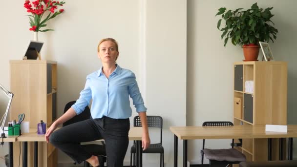 Ejecutiva femenina realizando yoga en su lugar de trabajo en la oficina. 4k, cámara lenta — Vídeos de Stock