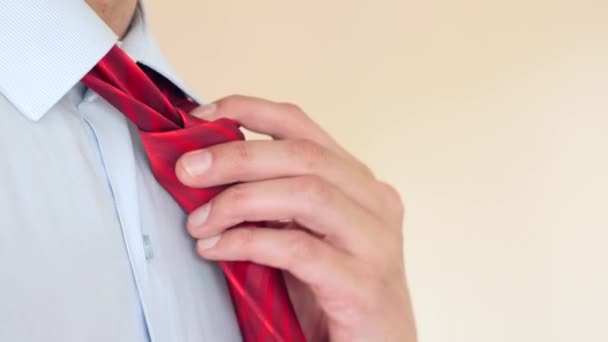 Un hombre de negocios se quita la corbata roja y desabrocha el botón superior de su camisa. 4k, cámara lenta, super primer plano. espacio para copiar — Vídeo de stock