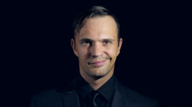 siyah bir arka plan üzerinde siyah giysili bir adam süper yakın çekim. 4 k. ağır çekim. adam puan parmak kamera.